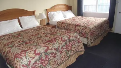a hotel room with two beds and a window at Empress Inn and Suites by the Falls in Niagara Falls