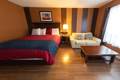 a hotel room with a bed and a chair at Villager Lodge Niagara Falls in Niagara Falls