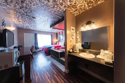 a bathroom with a sink and a bed in a room at Villager Lodge Niagara Falls in Niagara Falls