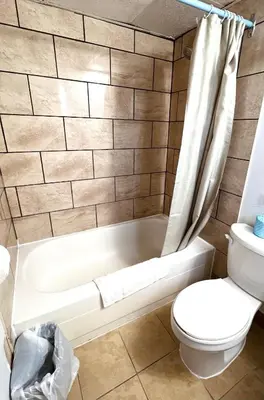 a bathroom with a toilet and a bath tub at Fairway Inn by the Falls in Niagara Falls