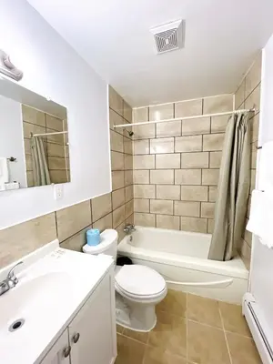 a bathroom with a toilet and a sink and a bath tub at Fairway Inn by the Falls in Niagara Falls