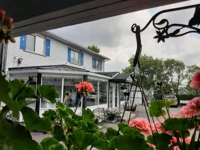 a house with flowers in front of it at Blue Moon Motel in Niagara Falls