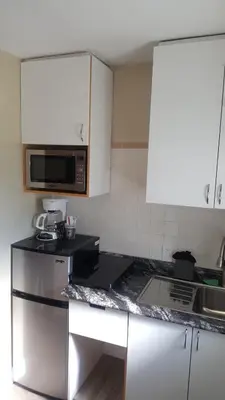 a kitchen with white cabinets and a black counter top at Blue Moon Motel in Niagara Falls