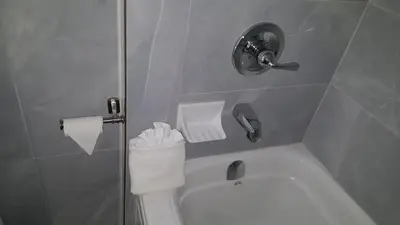 a bathroom with a white toilet and a shower at Blue Moon Motel in Niagara Falls