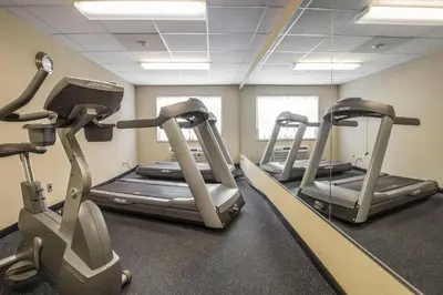 a gym with three tread machines in a room at Comfort Inn in Pickering