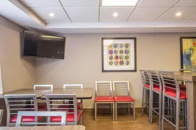 a restaurant with tables and chairs and a flat screen tv at Comfort Inn in Pickering