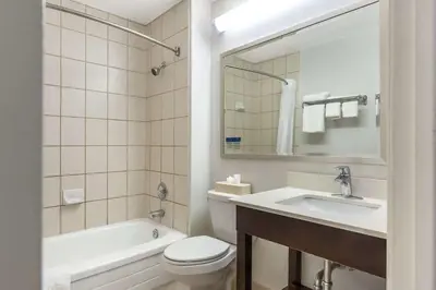 a bathroom with a toilet and a sink and a tub at Comfort Inn in Burlington