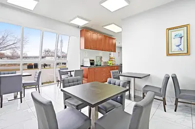 a dining room with tables and chairs and windows at Niagara Lodge & Suites in Niagara Falls