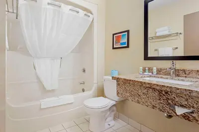 a bathroom with a toilet and a sink and a tub at Quality Inn in Peterborough