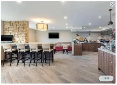 a kitchen and living room with a large table and chairs at Spark by Hilton Oshawa in Oshawa