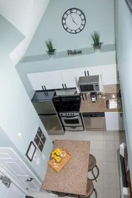 an overhead view of a kitchen with a clock on the wall at Mountain Side Condo Loft at The Blue Mountains in Blue Mountains
