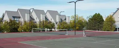 a tennis court with a net in front of a building at Mountain Side Condo Loft at The Blue Mountains in Blue Mountains