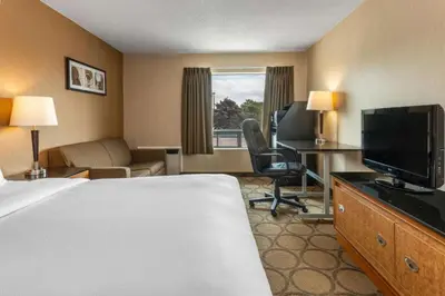 a hotel room with a bed and a flat screen tv at Comfort Inn in Orillia
