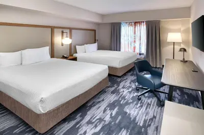 a hotel room with two beds and a desk and a chair at Fairfield Inn & Suites by Marriott Toronto Brampton in Brampton