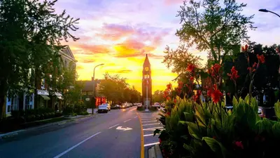a clock tower on a city street with a sunset at The White House Boutique B&B in Niagara on the Lake