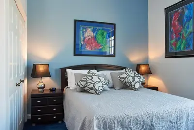 a bedroom with a bed with pillows and two lamps at Vine Village in Niagara on the Lake