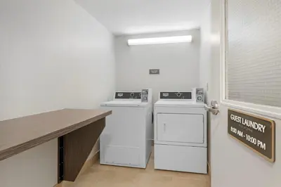 a laundry room with two machines and a counter at Comfort Inn in St. Catharines