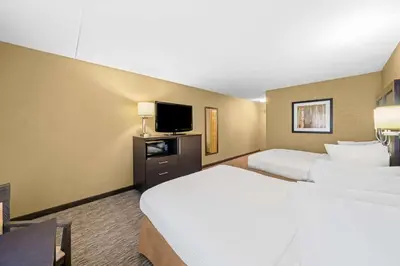 a hotel room with two beds and a flat screen tv at Best Western Plus Mariposa Inn & Conference Centre in Orillia