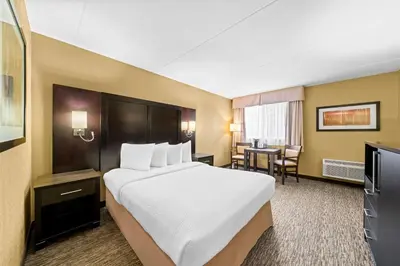 a hotel room with a large bed and a table at Best Western Plus Mariposa Inn & Conference Centre in Orillia