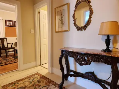 a room with a table and a mirror on the wall at Stone Carriage House in Picton