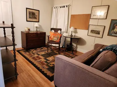 a living room with a couch and a chair at Stone Carriage House in Picton
