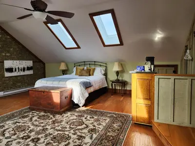 a bedroom with a bed and a ceiling fan at Stone Carriage House in Picton