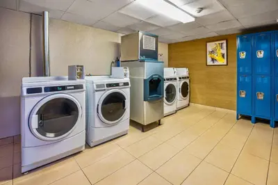 a laundry room with three washing machines and a washer and dryer at Comfort Inn in Guelph