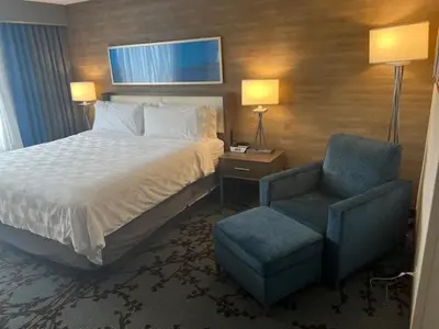 a hotel room with a bed and a chair at Holiday Inn - Mississauga Toronto West by IHG in Mississauga