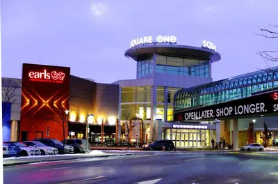 a building with cars parked in a parking lot at Holiday Inn - Mississauga Toronto West by IHG in Mississauga