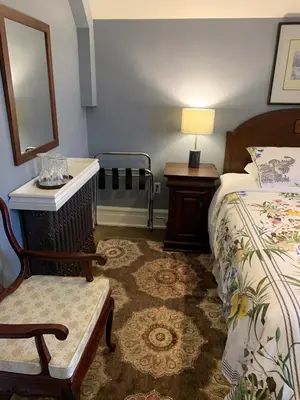 a bedroom with a bed and a chair and a mirror at Green Oaks B&B in Niagara on the Lake