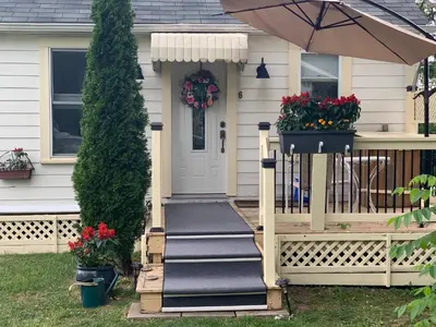a house with a front porch with an umbrella at Green Oaks B&B in Niagara on the Lake