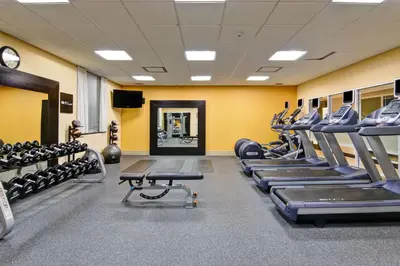 a gym with rows of treadmills and machines at Homewood Suites by Hilton Toronto Airport Corporate Centre in Toronto