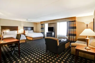 a hotel room with two beds and a desk at Homewood Suites by Hilton Toronto Airport Corporate Centre in Toronto