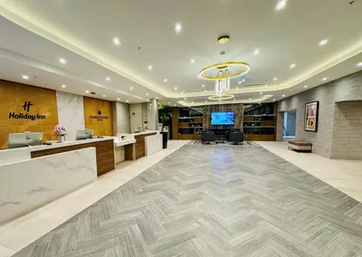 an office lobby with a reception desk and a television at Holiday Inn Burlington Conference Centre by IHG in Burlington
