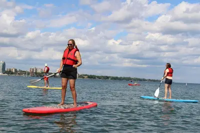 a group of people on paddle boards in the water at Holiday Inn Burlington Conference Centre by IHG in Burlington