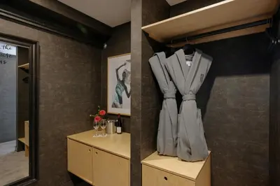a dressing room with a suit hanging on a wall at The Anndore House, part of JDV by Hyatt in Toronto