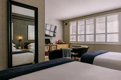 a hotel room with two beds and a mirror at The Anndore House, part of JDV by Hyatt in Toronto