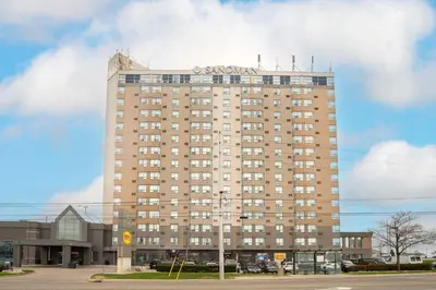a tall building with a sign on top of it at Sandman Signature Mississauga Hotel in Mississauga