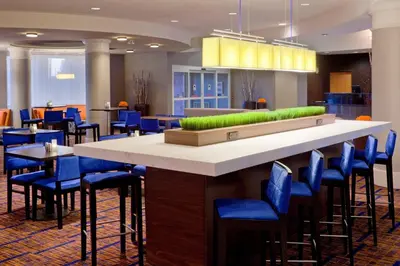 a lobby with a large bar with blue chairs at Courtyard by Marriott Toronto Mississauga/Meadowvale in Mississauga