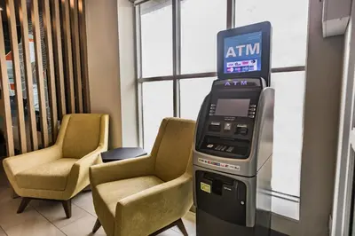 an atm machine in a room with two chairs at Holiday Inn Express Toronto-North York by IHG in Toronto