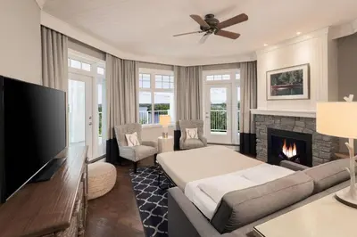 a living room with a bed and a fireplace at JW Marriott The Rosseau Muskoka Resort & Spa in Minett