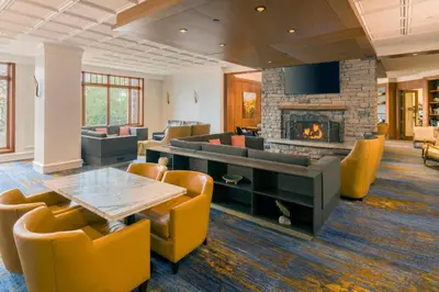 a lobby with a table and chairs and a fireplace at JW Marriott The Rosseau Muskoka Resort & Spa in Minett