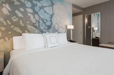 a bedroom with a large white bed and a painting at Courtyard by Marriott Toronto Vaughan in Vaughan