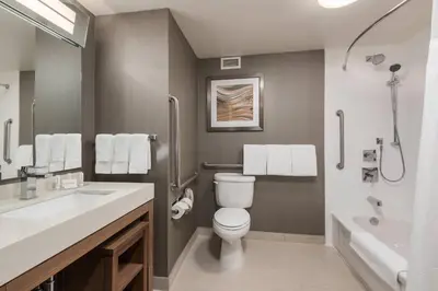 a bathroom with a toilet and a sink and a tub at Courtyard by Marriott Toronto Vaughan in Vaughan