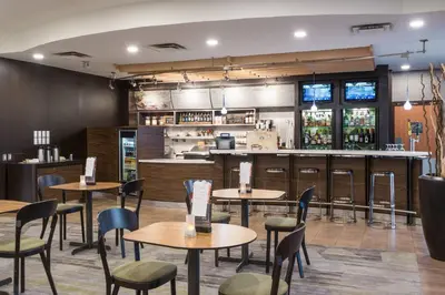 a restaurant with tables and chairs and a bar at Courtyard by Marriott Toronto Vaughan in Vaughan