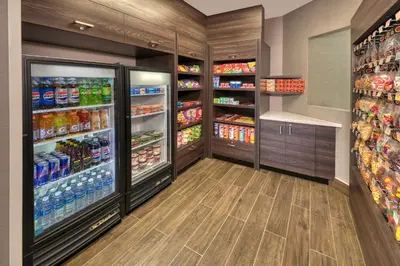 a large grocery store aisle with refrigerators and drinks at Residence Inn by Marriott Whitby in Whitby