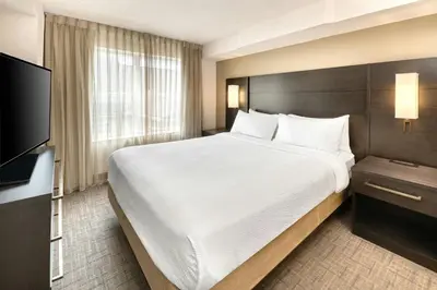 a bedroom with a large bed and a flat screen tv at Residence Inn by Marriott Whitby in Whitby