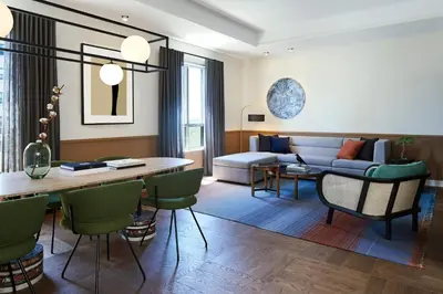 a living room with a couch and a table and chairs at Kimpton Saint George Hotel by IHG in Toronto
