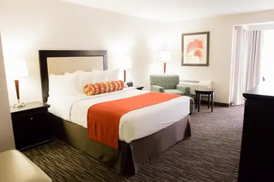 a hotel room with a large bed and a chair at Admiral Inn Hamilton in Hamilton