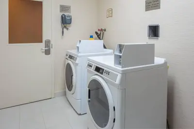 a white washing machine in a bathroom with a phone at Fairfield Inn & Suites by Marriott Belleville in Belleville